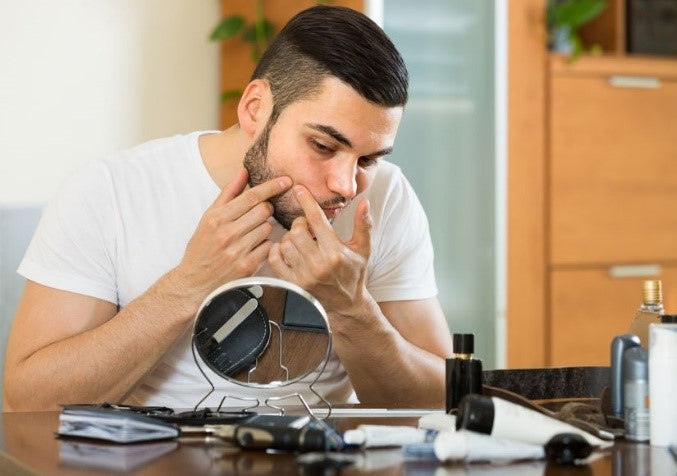 man popping pimples